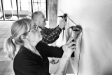 Per Rossling och Mia Widell arbetar med hängningen av den 16:e upplagan av teckningstriennalen Svart på Vitt.